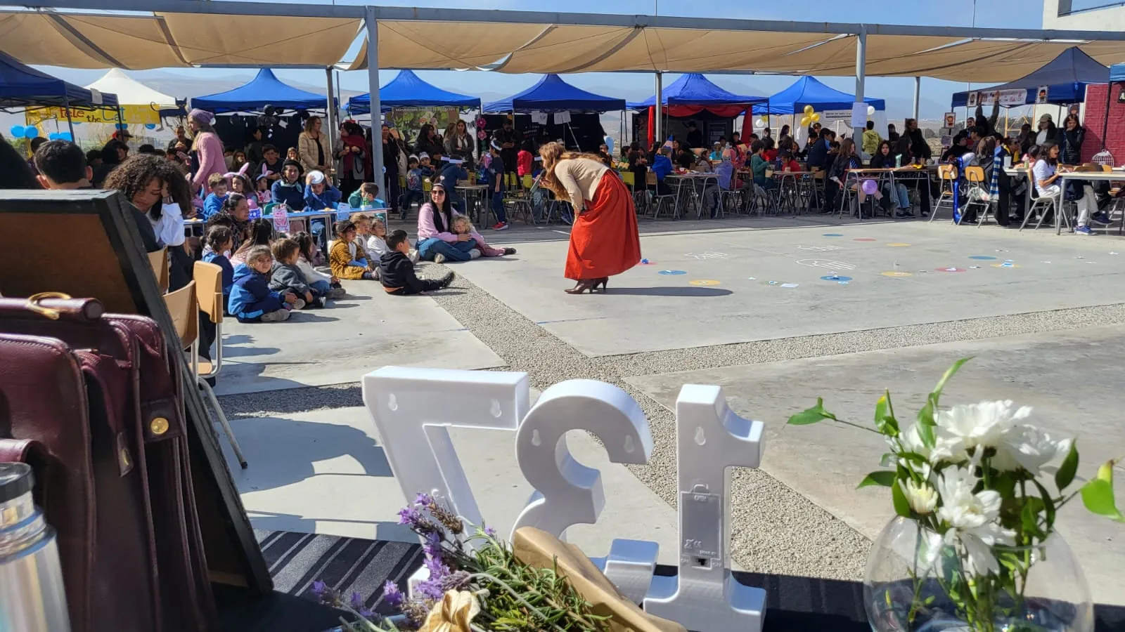 Panorámica del evento del Café Concert con stands y público del Lycée